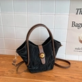 Bolso de cubo plisado negro con asas marrones y correa ajustable en mesa de madera - Negro