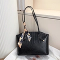 Close-up of black crocodile embossed tote bag featuring a decorative printed silk scarf - Black