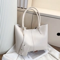 Detalle de bolso tote crema grande con estuche colgante sobre tela blanca texturizada - Blanco Roto