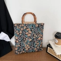 Bolso tote de flores con asas de bambú sobre mesa de madera, estilo oficina - Negro