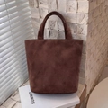 Dettaglio della trama della borsa tote in pelle scamosciata marrone scuro con luce naturale - Marrone