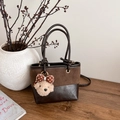 Details der Vintage-Eimertasche aus mattem Leder mit Plüsch-Anhänger und Schultergurt - Mit Anhänger / Braun