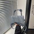 Chic crescent-shaped washed denim handbag in blue-gray with unique double knotted handle - Blue