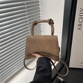 Dark brown leather crossbody bag with unique knot handles and a curved base silhouette - Brown
