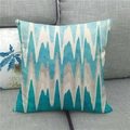 Linen cushion cover with teal and blue geometric zigzag pattern on a grey sofa - Blue Grey Horizontal Zigzag (12)