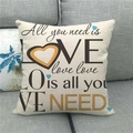 Detalle de funda de cojín de lino con texto All You Need Is Love en sofá de tela - All You Need is Love (3)