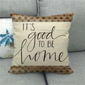 Close-up of linen pillow cover with printed text and brown floral geometric borders - It's Good To Be Home Floral