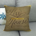 Detailed close-up of linen cushion with More Home text on a dark gray sofa - Less House More Home Retro