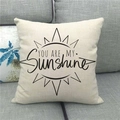 Close-up of linen cushion cover with YOU ARE MY Sunshine text on a grey fabric sofa - You are my sunshine Sun (13)