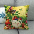Detail eines Leinenkissenbezugs mit Vögeln Beeren und Gänseblümchen auf grauem Sofa - Blaurücken-Vogel und Beeren Stil (4)