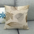 Nahaufnahme des Leinen-Kissenbezugs mit herbstlicher Ahornblatt-Textur auf grauem Sofa - Blattader-Textur Stil