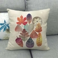 Close-up of linen cushion cover with colorful autumn maple leaf patterns on a grey sofa - Autumn Leaf Composition Style