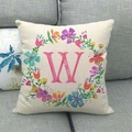 Dettaglio copricuscino in lino con ghirlanda floreale e lettera W rosa su divano grigio - 45*45cm / Lettera W (23)