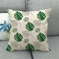 Square linen pillowcase with monstera leaf pattern on a grey fabric sofa background - Green Grey Leaf Style (12)