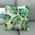 Nordic monstera leaf print linen pillow cover on dark grey sofa in home setting - Watercolor Monstera Style (11)