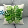 Linnen kussenhoes met monstera- en palmbladprint op een moderne grijze bank - Monstera en palmbladeren op gebroken wit (4)