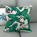 Close-up of linen pillowcase with green tropical leaves and decorative black text - Tropical Plants with Decorative English Text (8)