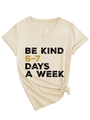 Detail of the V-neckline and BE KIND typography on this light beige cotton t-shirt - S / Sand (Black Graphics)