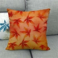 Detail of linen autumn pillow cover with red maple leaf pattern on a grey fabric sofa - Realistic Bright Orange Maple Style