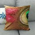 Detail eines Pfauenfeder-Prints auf einem Leinen-Kissenbezug auf einem grauen Sofa - Rosa und Grüne Teilnahaufnahme Pfauenfeder (17)