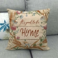 Detailansicht des Happy Fall Leinen-Kissenbezugs mit Kranzdesign und Spruch auf Sofa - Beige Holzmaserung It's good to be HOME Stil (4)
