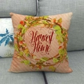 Close-up of Harvest Home autumn wreath linen pillowcase on a cozy grey sofa - Orange Pink Striped Harvest Home Wreath Style (6)