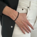 Dettaglio del bracciale di perle geometriche nero opaco su modella con giacca di pelle - Bracciale Sfaccettato Geometrico Irregolare(03050)