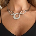 Détail d'un collier chaîne argentée avec pendentifs ovales creux sur un mannequin - Collier à Anneaux Géométriques / Argent (07604)