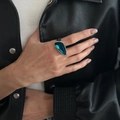 Close-up of a bold geometric blue crystal ring on a model wearing a leather jacket - Green Geometric Ring (00967)