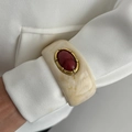 Detail of vintage ivory marble resin bangle with oval red gemstone and gold setting - Beige