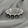 Macro-opname van zilveren stretcharmband met grijze vierkante kristallen op fluweel - Zilveren Armband/Zwarte Vierkante Edelstenen (03055)