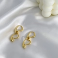 Polierte 18K vergoldete Tropfenohrringe auf weißer Seide im minimalistischen Stil - Gold