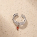Detailed view of silver lava texture open ring with a red pear-cut zircon stone pendant - One Size / Silver