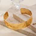 Detail of 18K gold-plated cuff bracelet featuring a hammered texture and cutout leaf pattern - Gold