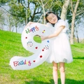 Little girl holding a 40-inch white number 9 balloon with colorful Happy Birthday prints - Number 9