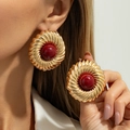 Boucles d'oreilles rétro en métal doré torsadé avec dôme bordeaux portées par mannequin - Style de Disque en Spirale à Centre Rouge et Base en Or (03880)