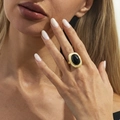 Macro shot of a vintage gold ring featuring a large oval black gemstone on a finger - Silver Tone + Black (00993)