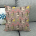 Housse de coussin décorative en lin avec motif de renne et forêt sur un canapé gris - Style Renne et Forêt (1)