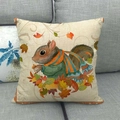 Funda de cojín de lino con ardilla navideña y hojas de otoño en un sofá acogedor - Patrón de Ardilla / 45x45 cm