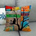 Artistieke kussenhoes met katten-silhouet op een grijze stoffen bank gepresenteerd - 45x45cm / Artistieke Collage Zwarte Kat (2)