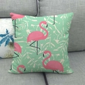 Close-up of pink flamingo and leaf print on mint linen cushion cover on a grey sofa - Fresh Mint Green Flamingo (16)
