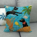 Detail of tropical seaside dog pattern cushion cover on a grey sofa for home decor - Labrador Surfing Theme