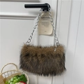 Borsa tote marrone in pelliccia sintetica con catena argento appesa a una porta bianca - Kaki