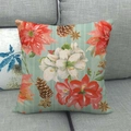 Détail de housse de coussin en lin avec poinsettia et pommes de pin sur canapé - Floral de Noël à Rayures Sarcelle / 45x45 cm