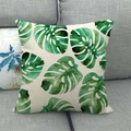 Close-up of watercolor monstera leaf pattern on linen pillowcase over gray sofa - Variegated Monstera Style (3)