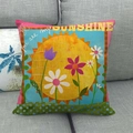 Cartoon Sonnenblume Kissenbezug aus Leinen mit Blumen-Patchwork auf einem grauen Sofa - Sunshine Floral Collage Stil