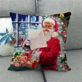 Close-up of linen Christmas pillow cover featuring Santa reading a letter on a gray sofa - Santa Reading Letters (13) / 18x18 Inch