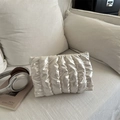 Clutch a nuvola trapuntata bianco crema con finitura satinata su divano minimalista - Bianco