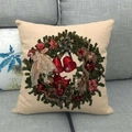 Detalle del estampado de corona navideña en funda de almohada de lino beige en sofá - Estilo de Corona con Campanas y Ángeles Vintage (3)