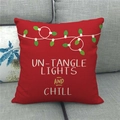 Detail of red Christmas linen pillowcase featuring festive light graphics and text on a sofa - Red Festive Lights (6)